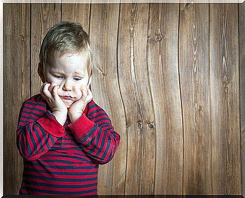 A frustrated child grabs his face.