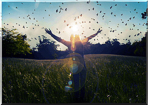 A woman with her arms outstretched greets the world. 