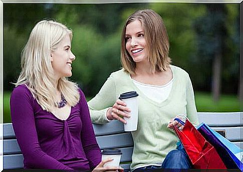 Women talk on a park bench.