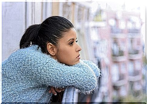 A woman on her balcony, lost in thought.