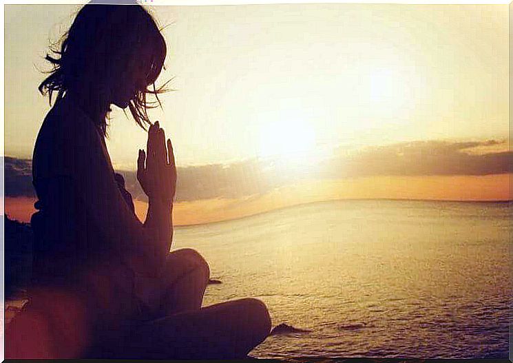 Meditating woman by the sea