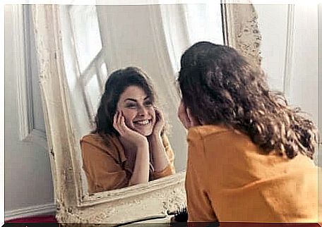 Increase in self-esteem - woman smiles at herself in the mirror