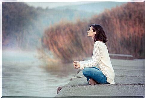 Woman practices mindfulness by a lake