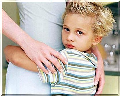 A boy clings to his mother.