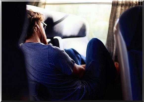 A young man fell asleep in a chair. 