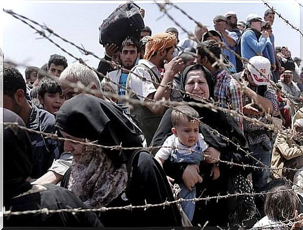 Refugees at chain link fence