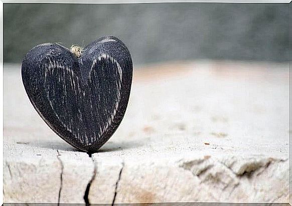 The Law of Attraction - Small wooden heart stuck in a crack in wood.